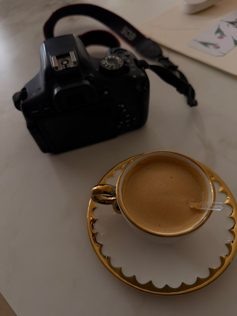 Bastidores do estúdio vilas.mkt: câmera e café sobre a mesa de trabalho